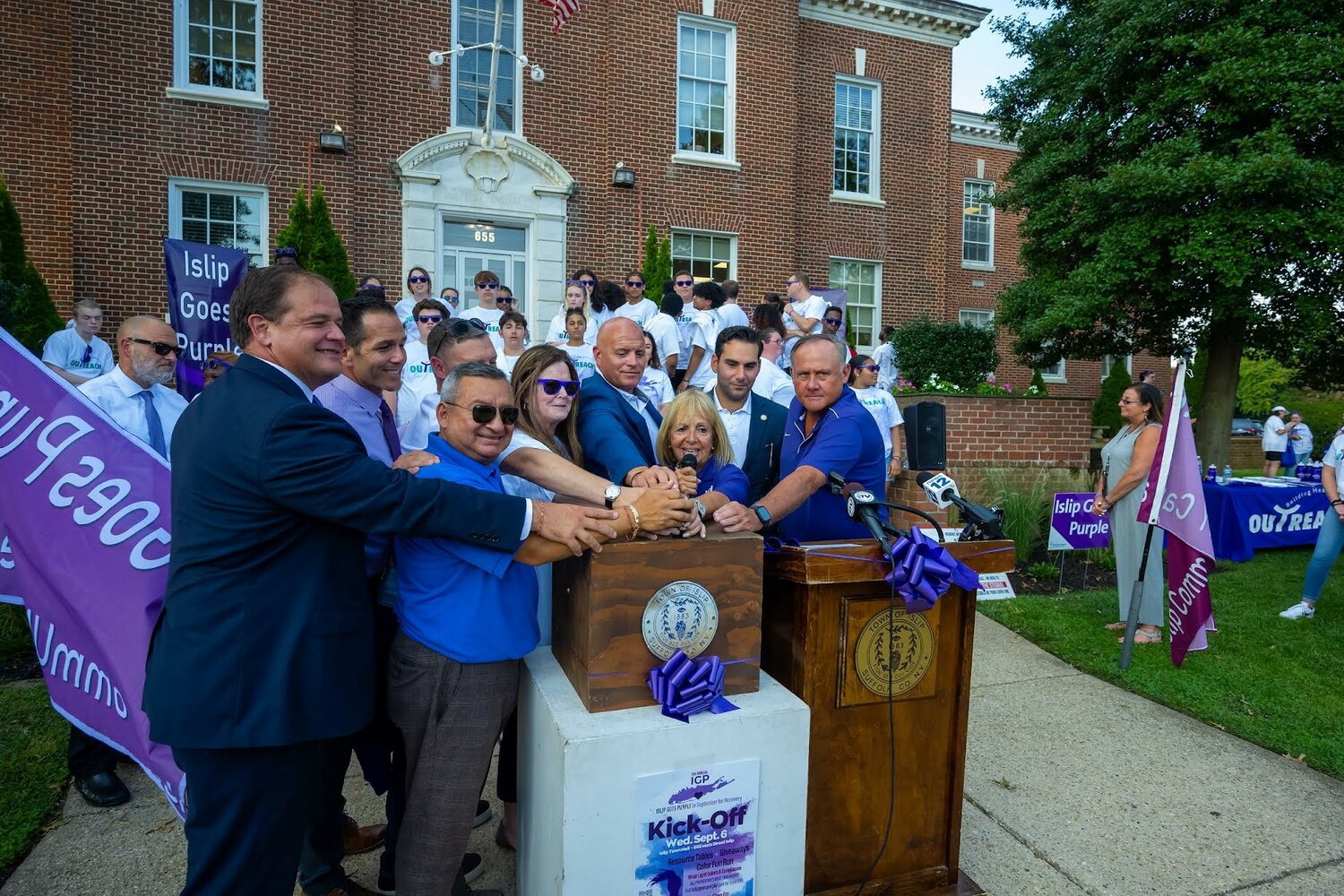 Angie Carpenter and others turn on the switch to make Town Hall purple.